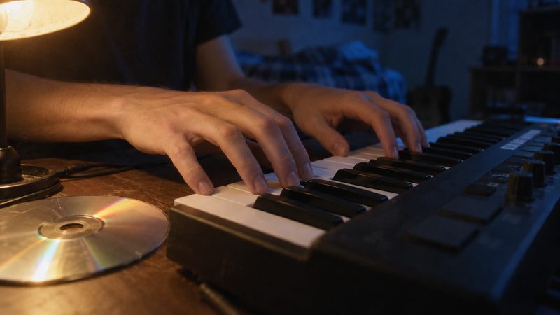 Hands on the keys, a blank CD beside them